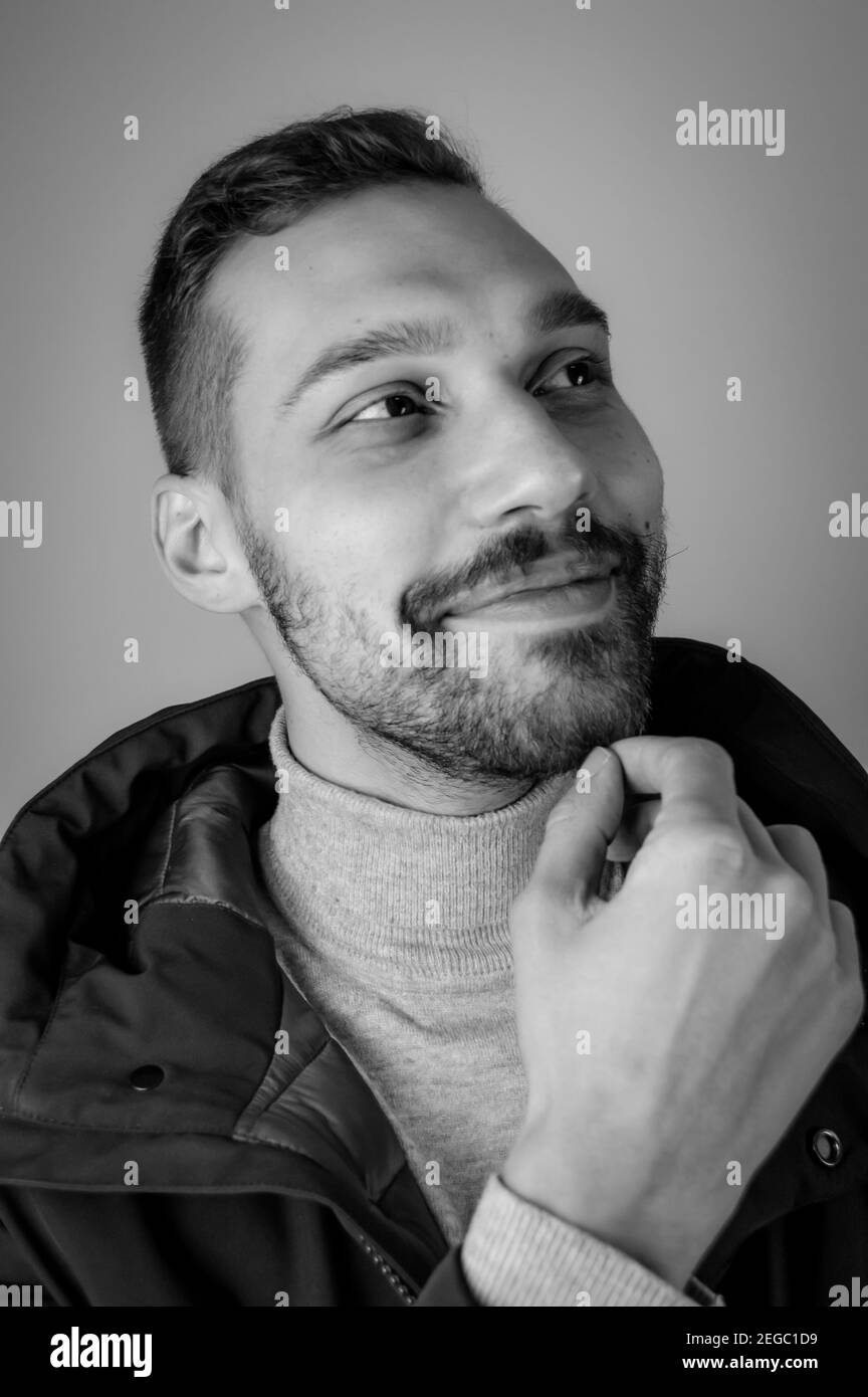 Black and white portrait of a young man touching his chin in a moment ...