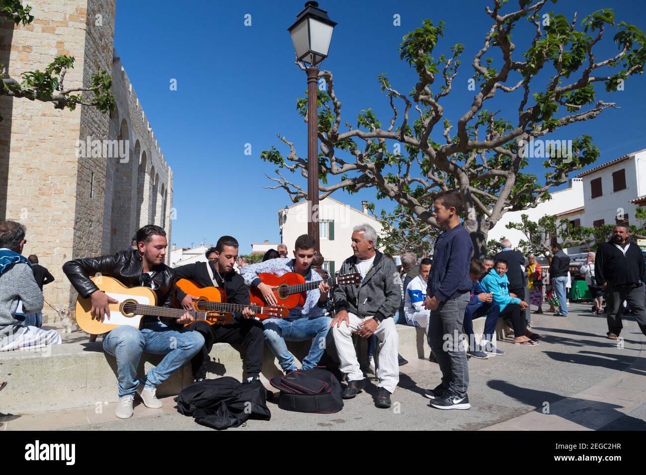 France Saintes Maries De La Mer Romani men playing traditional music in the street during the annual prilgrimage in May. Stock Photo