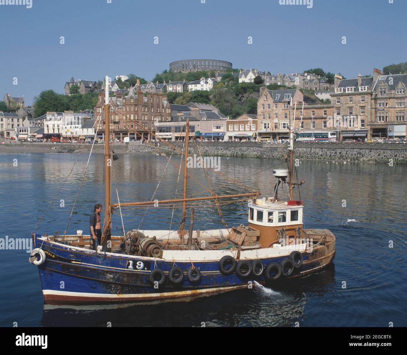 Scotland. Oban. View of town harbour waterfront with fishing boat. Stock Photo