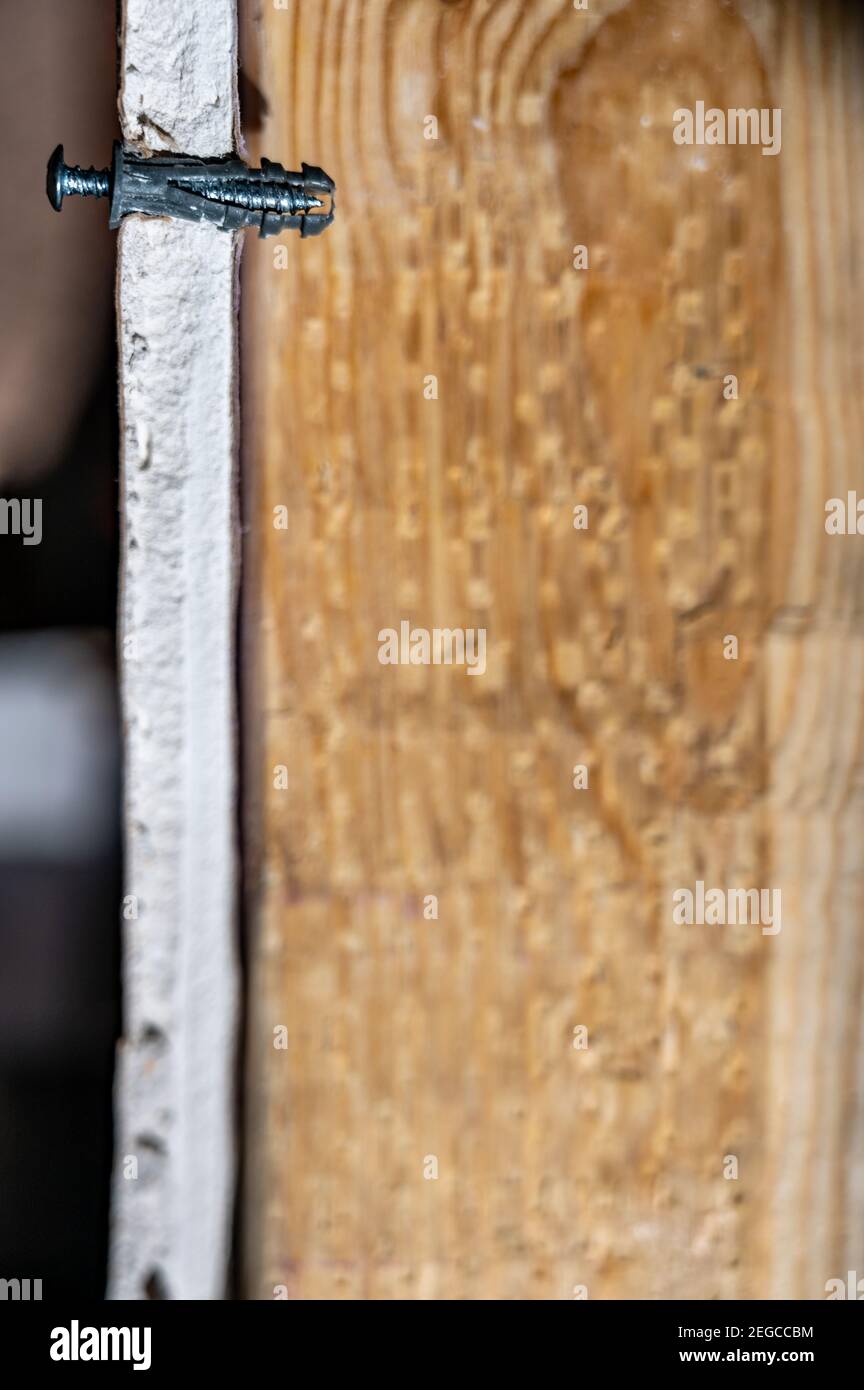 Side view of a drywall mount anchor and screw for hanging objects on
