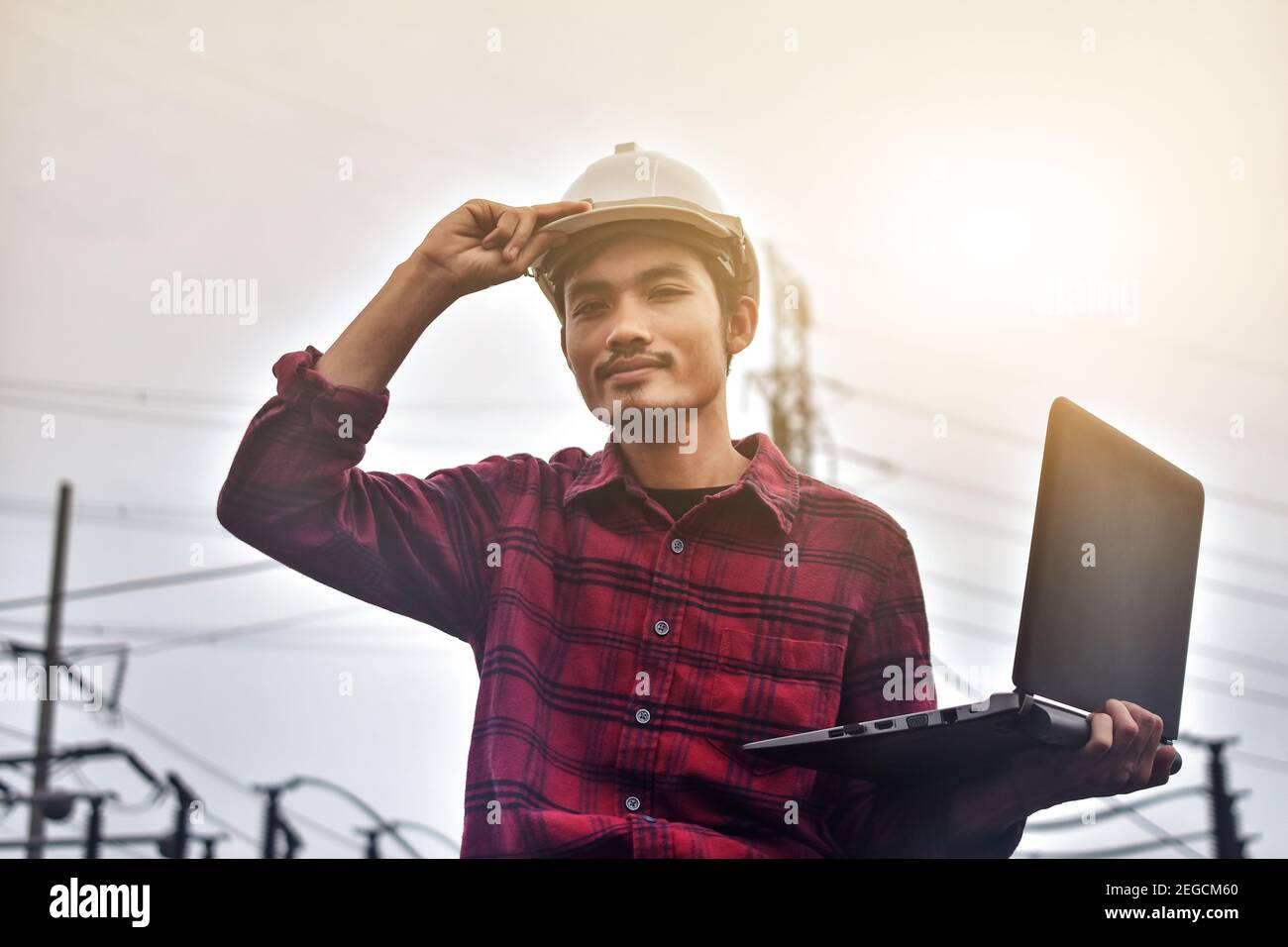 Engineer hold laptop computer inspection on site power plant high volte system Stock Photo