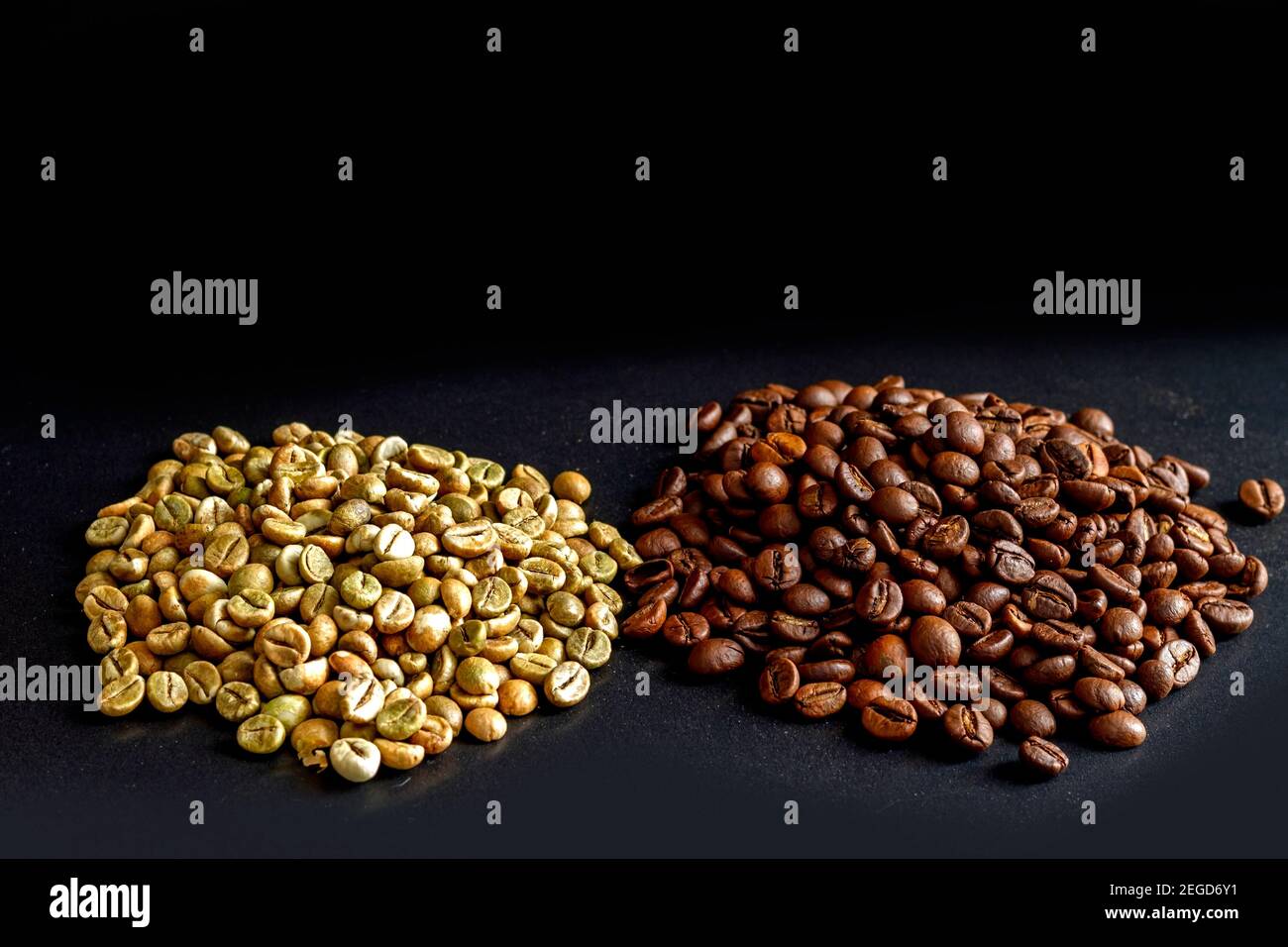 Unroasted and roasted coffee beans of the Robusta variety on a black background. Green unroasted