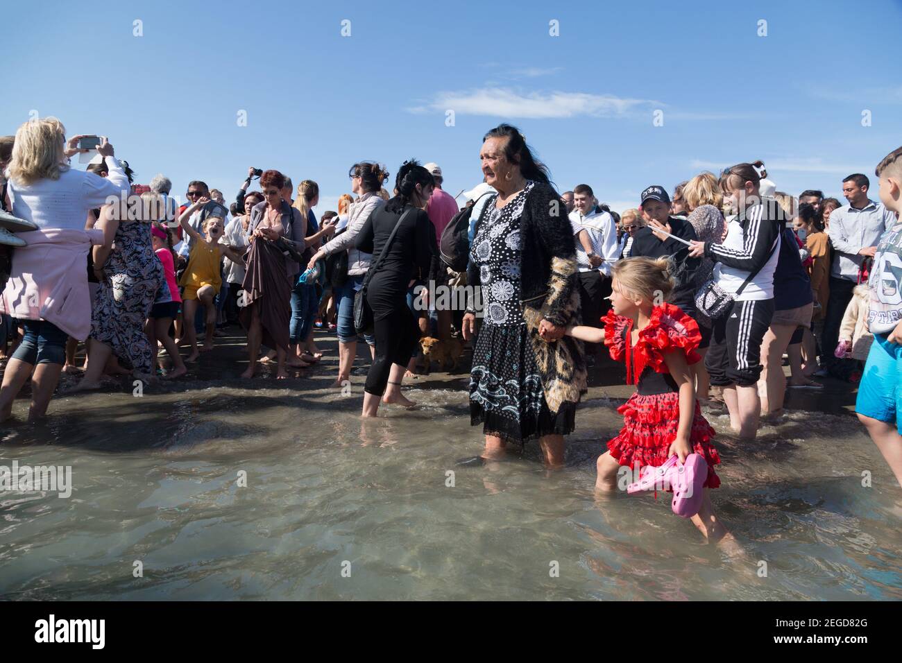 As the statue of the Gypsy Patron Saint Sarah is taken into the sea in the annual procession, the crowd rejoices in celebration. Stock Photo