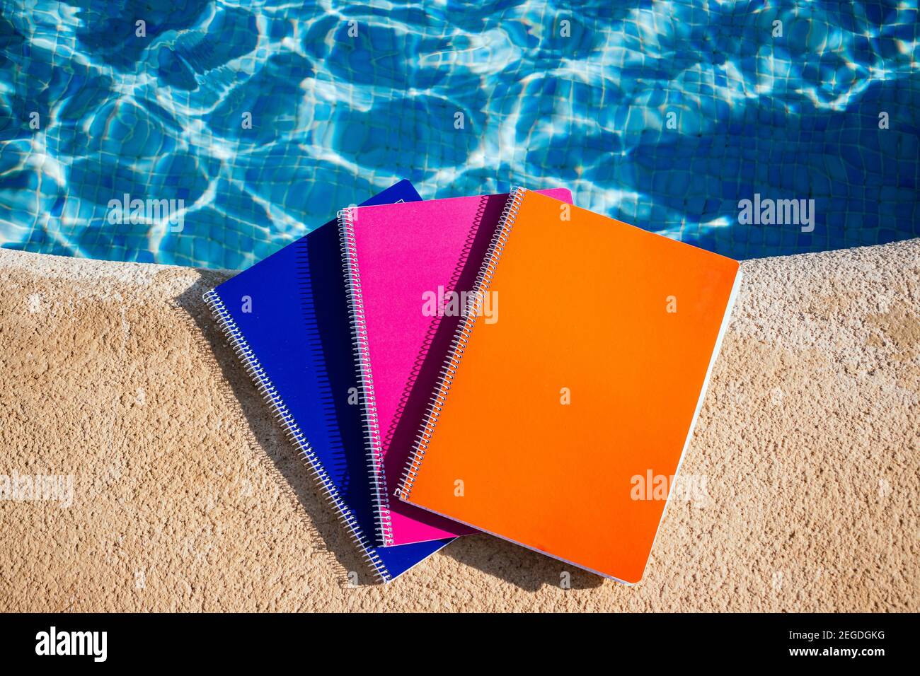 colored notebooks next to a pool Stock Photo