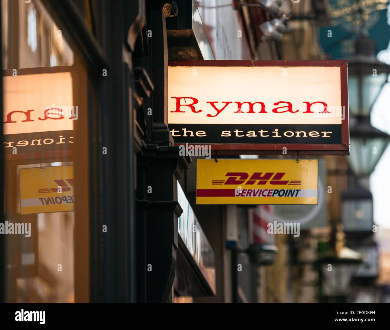 Ryman the stationer stationery store shop sign with window reflection, and DHL Service Point sign below, Birmingham, UK Stock Photo