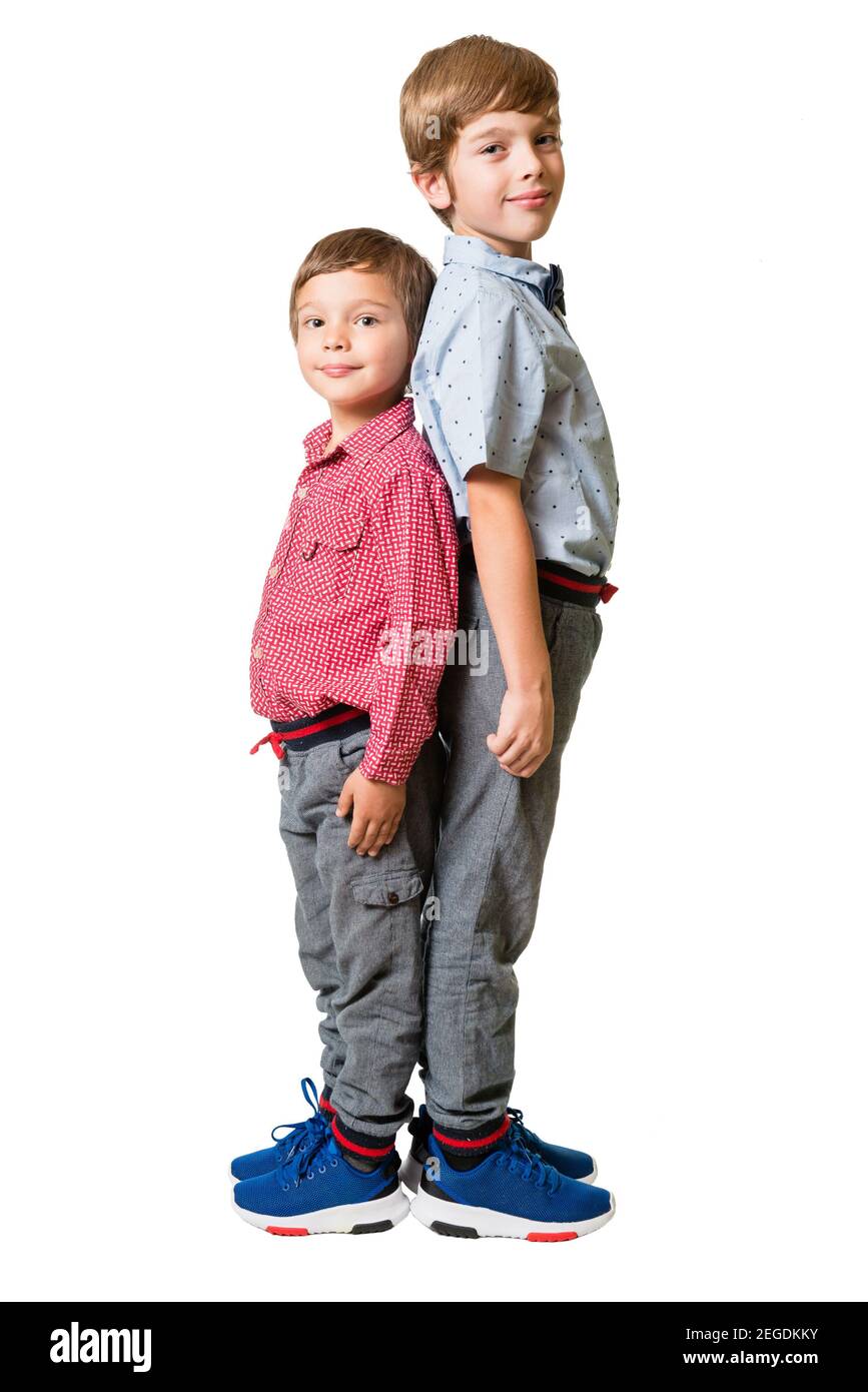 Two young boys standing back to back, isolated on white background Stock Photo