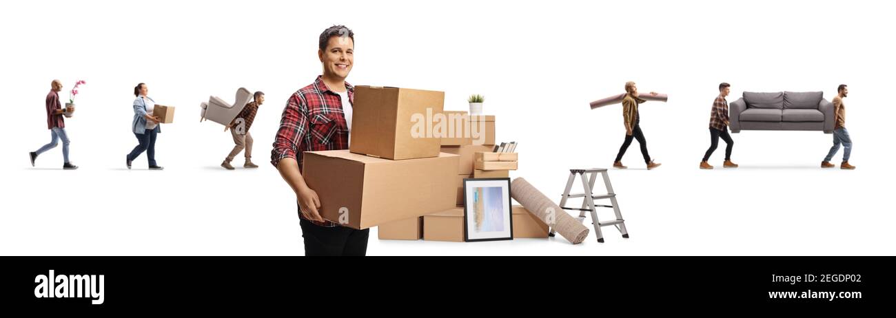 Smiling man carrying boxes and other people moving household items ...