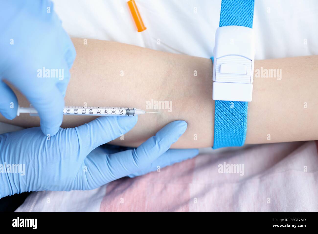 Nurse giving intravenous injection of medication to patient closeup