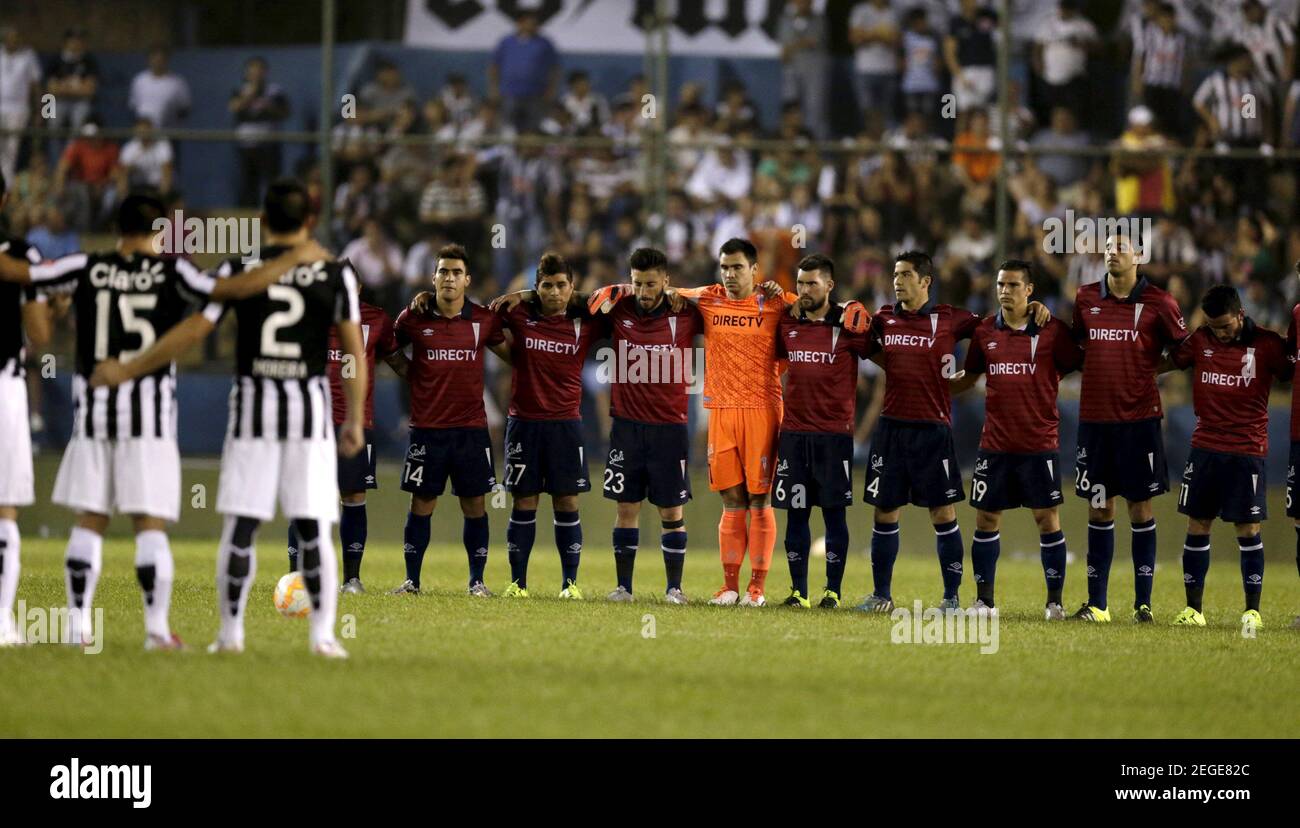 Players of Chile's Universidad Catolica (red) and Paraguay's Libertad take a moment of silence in memory of the victims of the Chilean earthquake on Wednesday, before their Copa Sudamericana soccer match at the Nicolas Leoz Stadium in Asuncion September 17, 2015. REUTERS/Jorge Adorno    Picture Supplied by Action Images Stock Photo