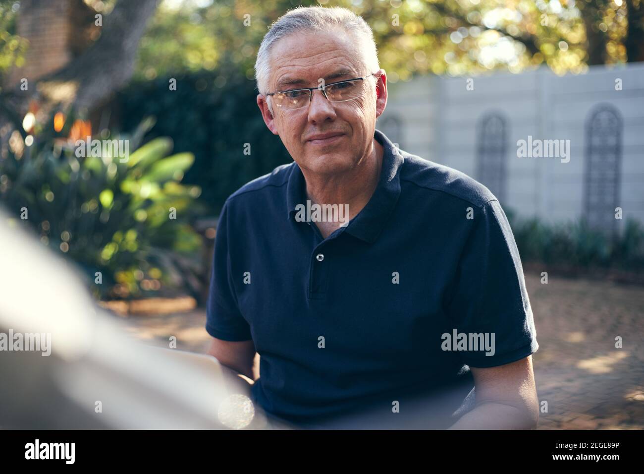 Small business owner mechanic smiling at camera whilst on laptop Stock Photo