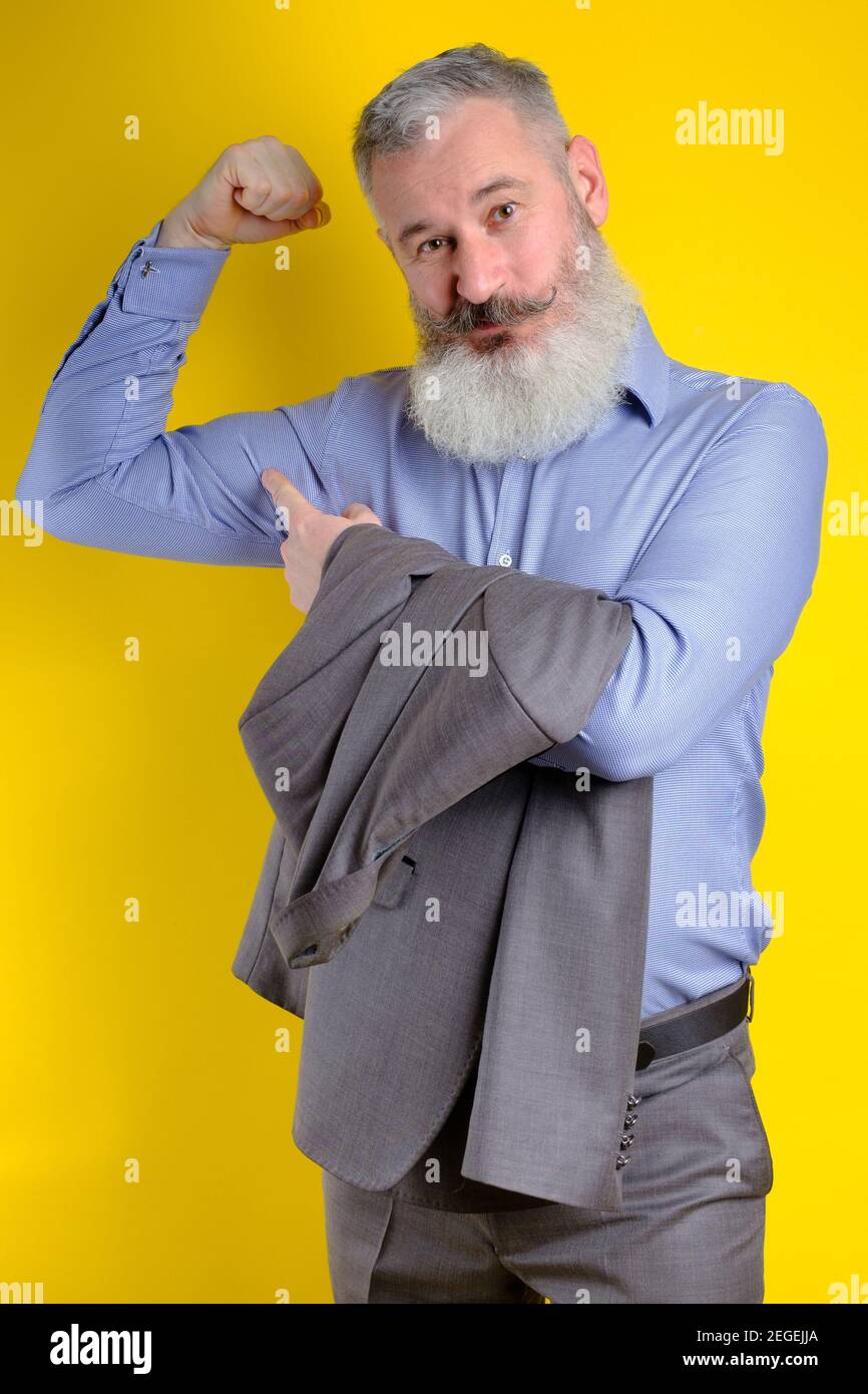 Studio portrait mature businessman dressed in gray suit shows his ...