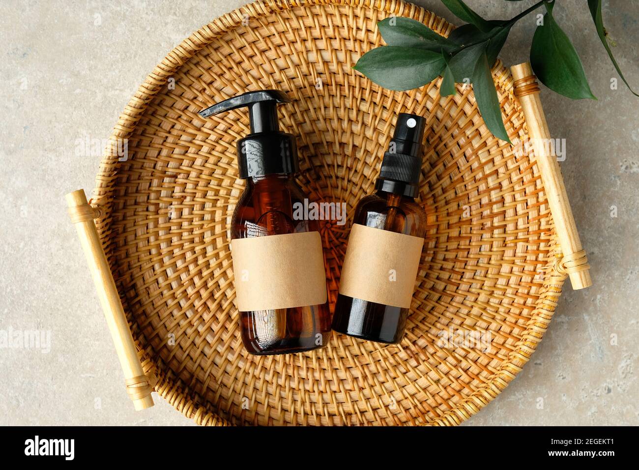 Set of amber glass bottles of natural cosmetics for personal hygiene in rattan tray. SPA organic beauty products top view. Stock Photo