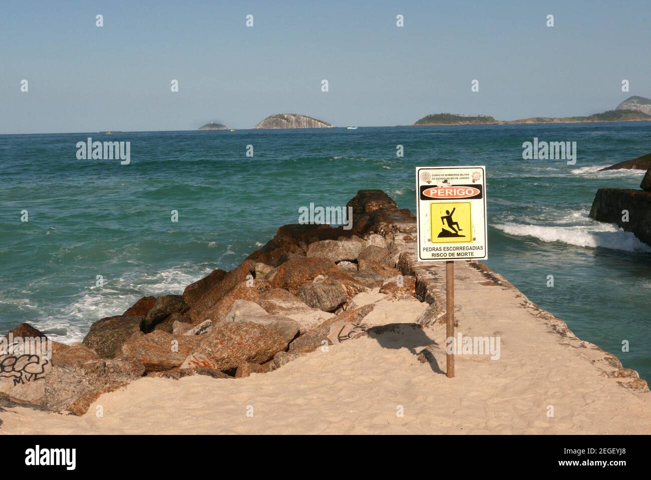 Warning sign on the rocky waterfront in Leblon Rio de Janeiro Brazil. Stock Photo