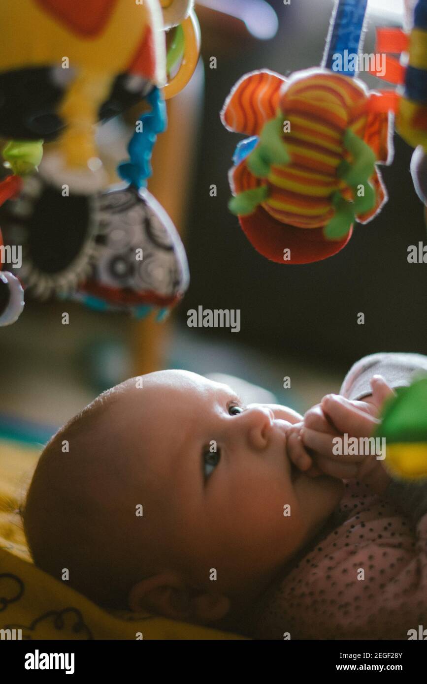 Baby girl looking at a toy mobile Stock Photo