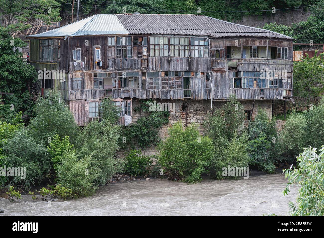 Collapsing plank house over the rough waters of the Rioni River, Kutaisi, Georgia. Stock Photo