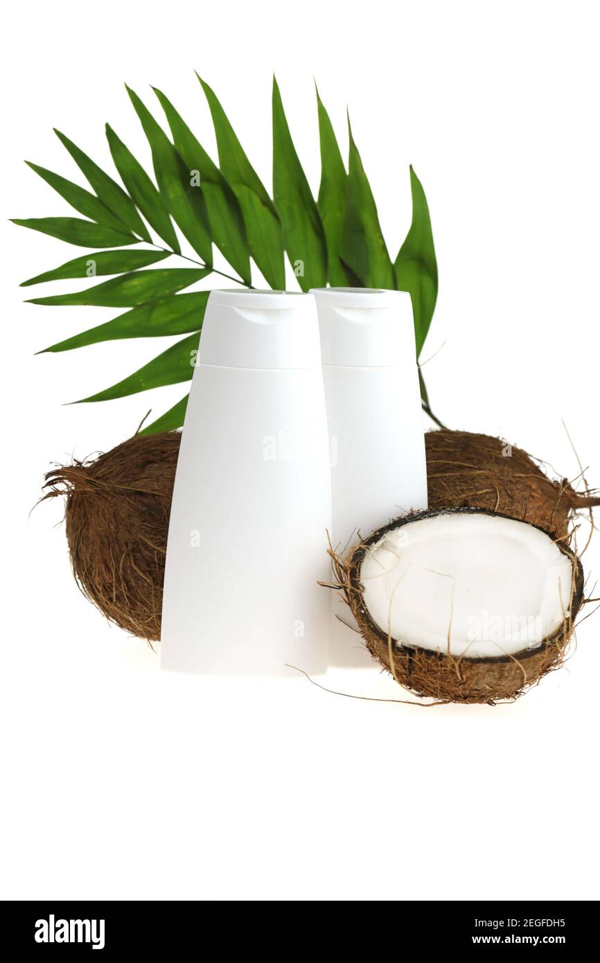 Coconut oil. White bottles mockup and coconuts set with palm green leaf