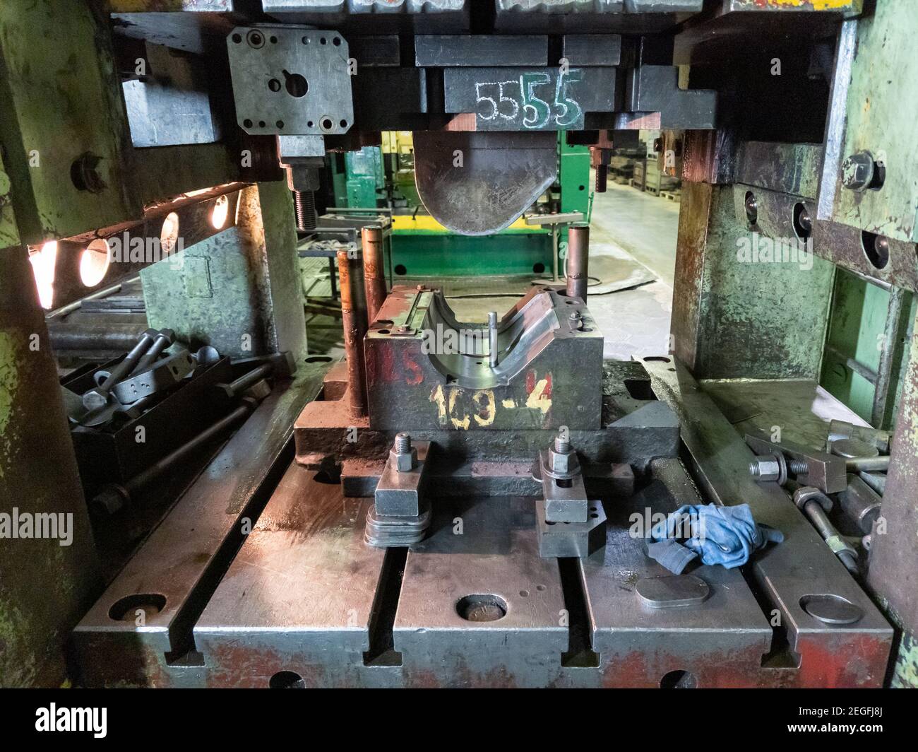 dirty used low tech stamping press with sheet metal die tooling. Stock Photo