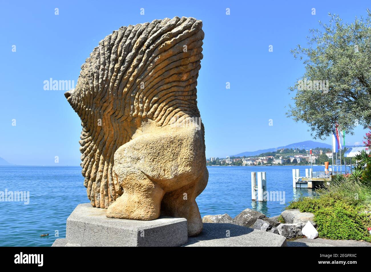 Stone sculpture of a fish with human legs on Leman (Geneva) lakeshore, Montreux Riviera, Switzerland. Stock Photo