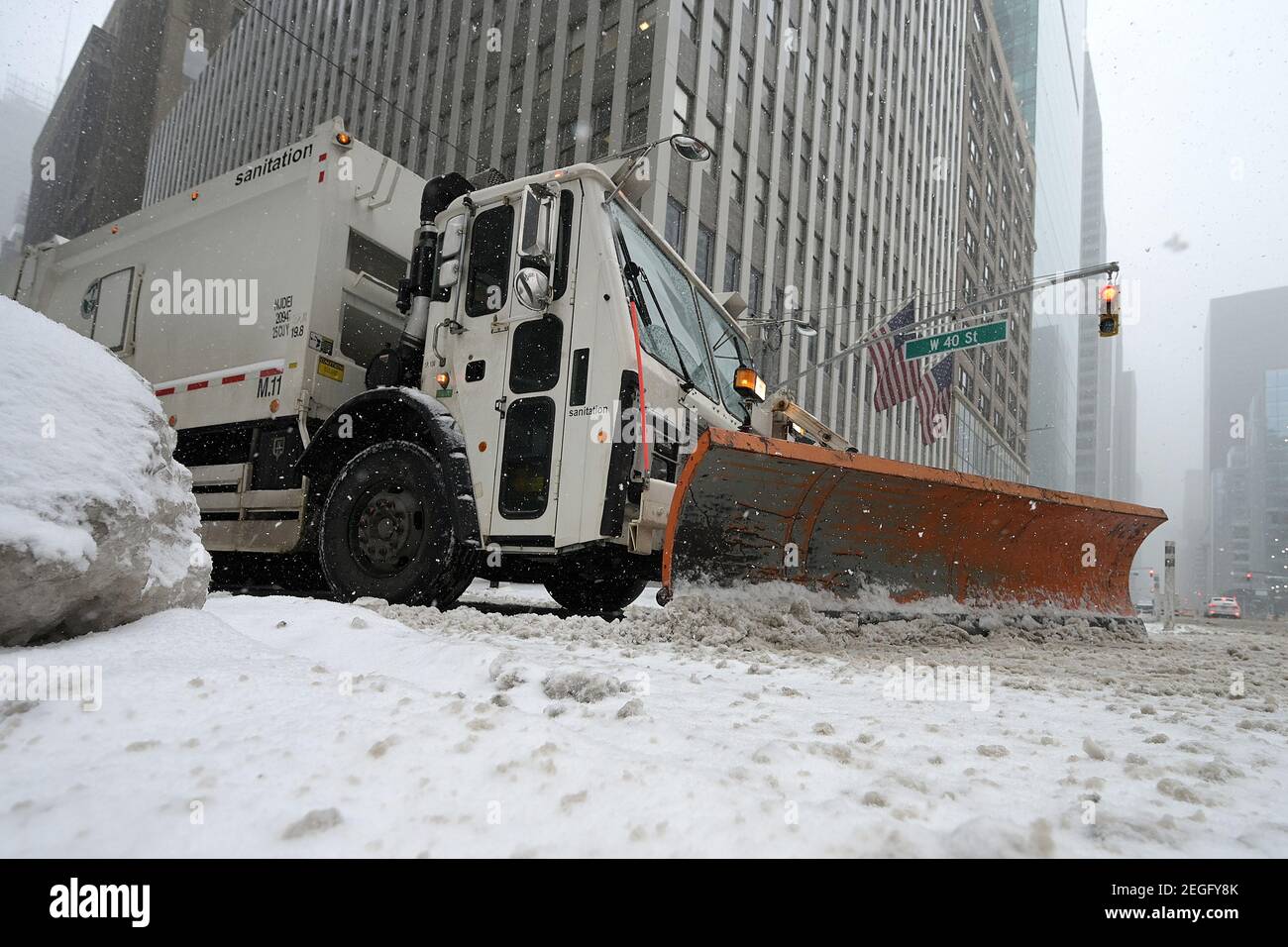 New York, USA. 18th Feb, 2021. A New York City Sanitation Department truck fitted with a snow plow makes its way down 40th Street during a winter storm expected to bring more than a foot of snow over the next two days, New York, NY, February 18, 2021. The National Weather Service has issued a winter storm watch for the tri-state area, as much of the nation suffers through winter blast the past few days. (Photo by Anthony Behar/Sipa USA) Credit: Sipa USA/Alamy Live News Stock Photo