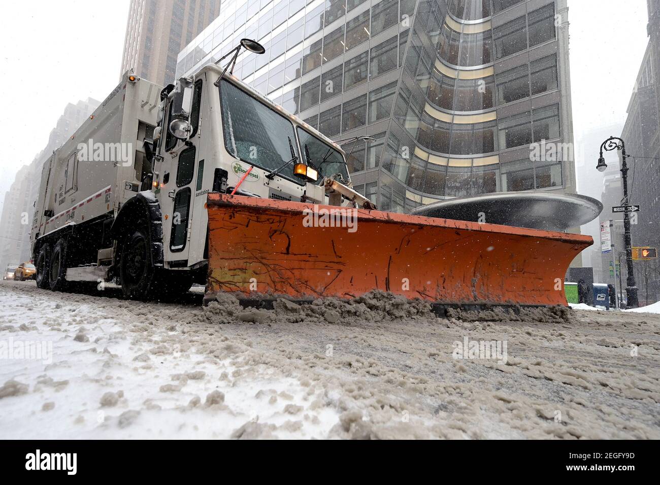 New York, USA. 18th Feb, 2021. A New York City Sanitation Department truck fitted with a snow plow makes its way up Avenue of the Americas during a winter storm expected to bring more than a foot of snow over the next two days, New York, NY, February 18, 2021. The National Weather Service has issued a winter storm watch for the tri-state area, as much of the nation suffers through winter blast the past few days. (Photo by Anthony Behar/Sipa USA) Credit: Sipa USA/Alamy Live News Stock Photo