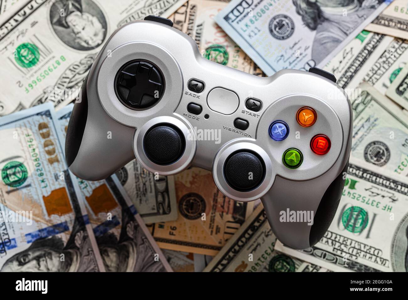 Silver wireless gamepad on dollar bills Stock Photo
