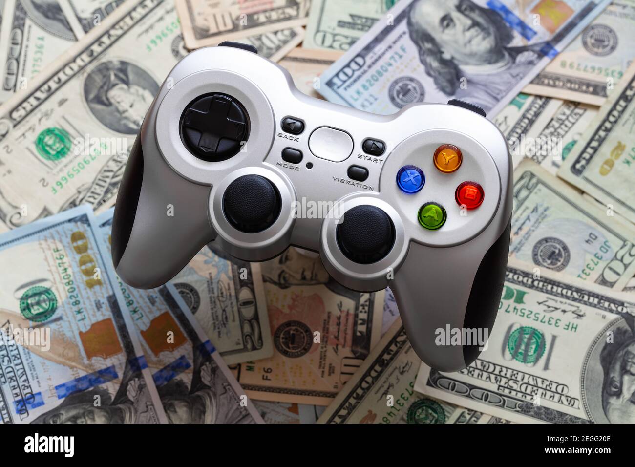 Silver wireless gamepad on dollar bills Stock Photo