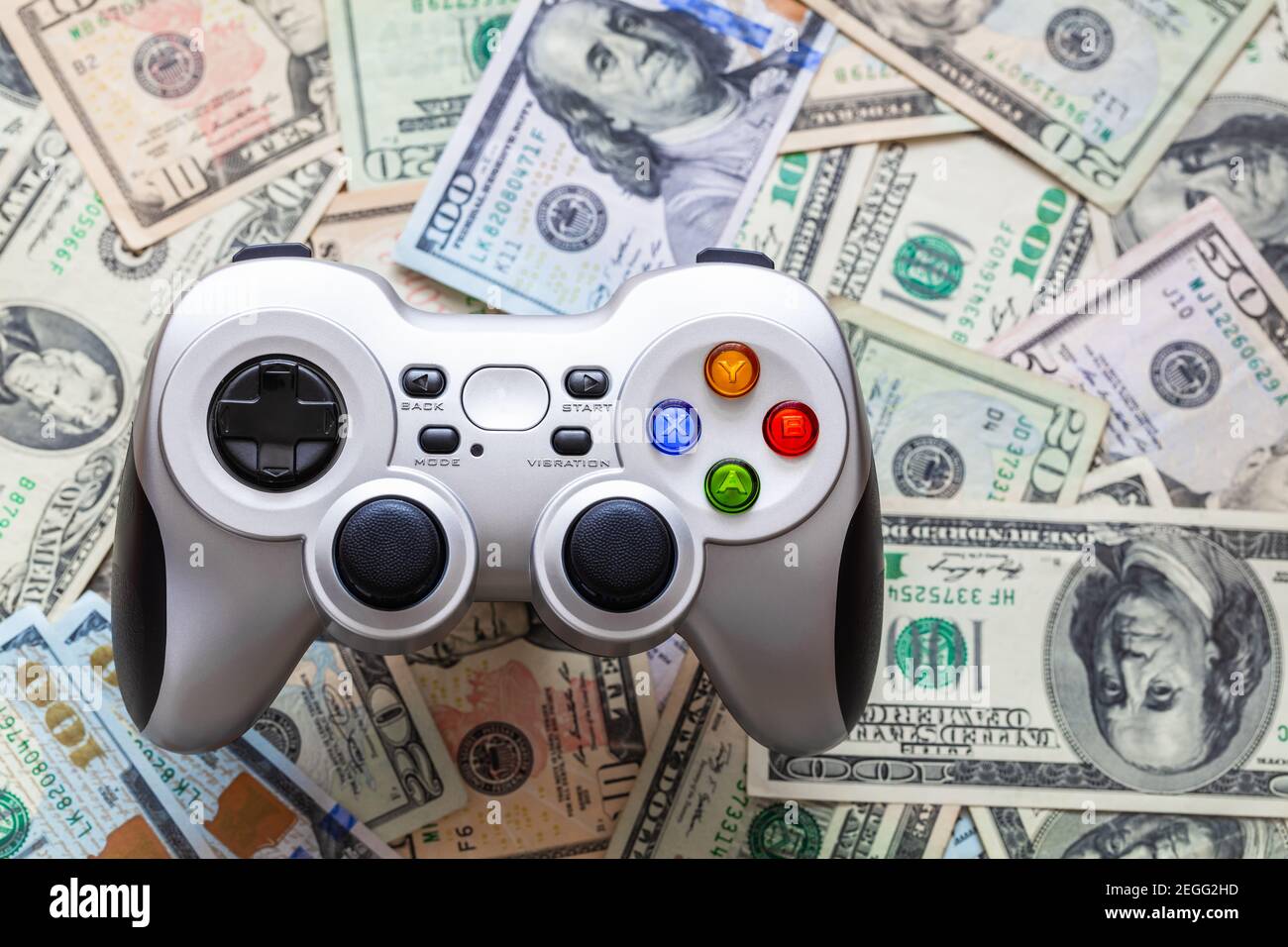Silver wireless gamepad on dollar bills Stock Photo