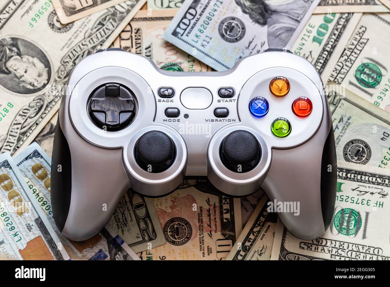 Silver wireless gamepad on dollar bills Stock Photo