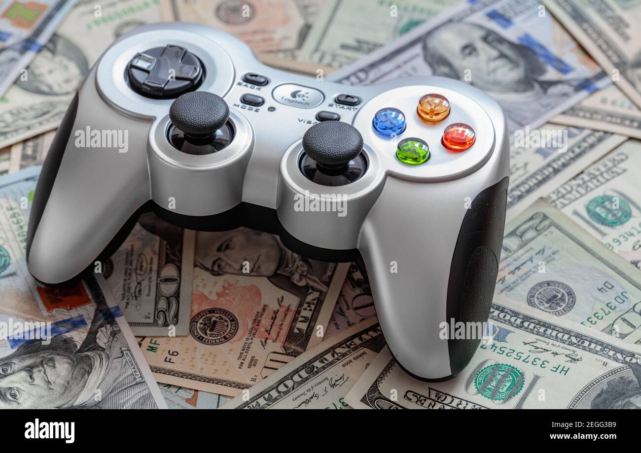 Silver wireless gamepad on dollar bills Stock Photo