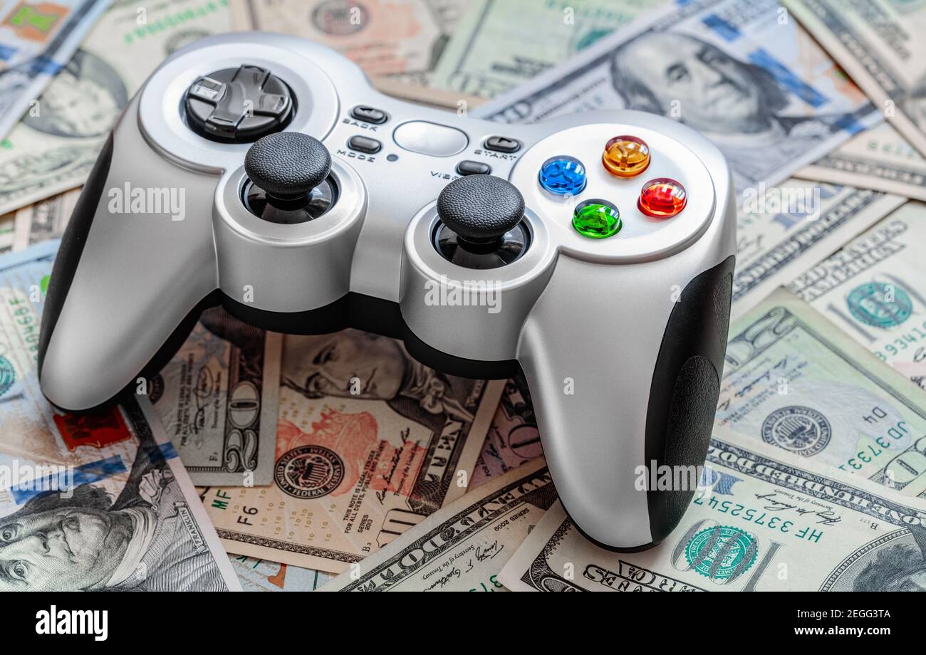 Silver wireless gamepad on dollar bills Stock Photo