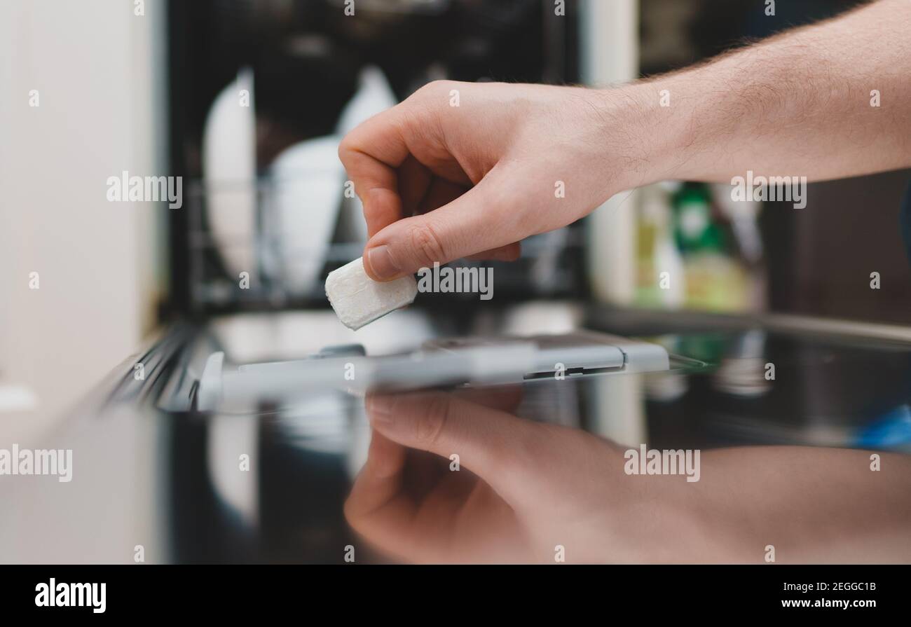 Man putting detergent tablet into dishwasher Stock Photo Alamy