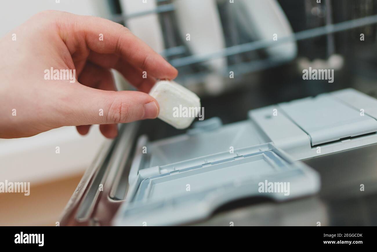 Man putting detergent tablet into dishwasher Stock Photo Alamy