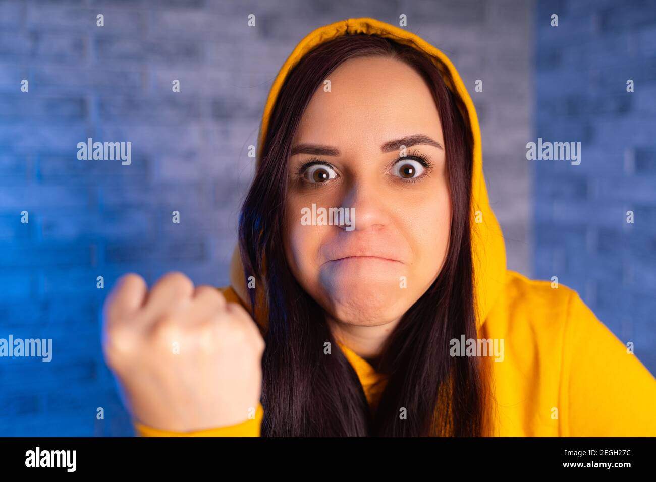 Portrait of dissatisfied young woman showing fist. Close up of ...