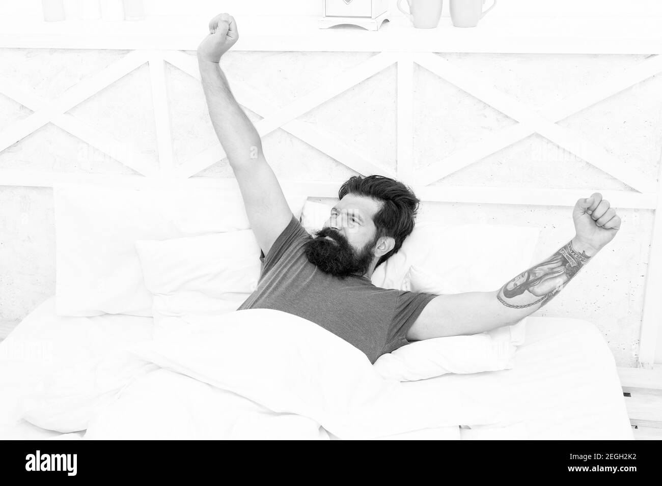 Nice morning. lazy sunday. bed time routine. brutal male stretching. relax lifestyle concept. bearded man in bed. early wake up at morning. bachelor feel comfortable. guy rest at bedroom. Stock Photo