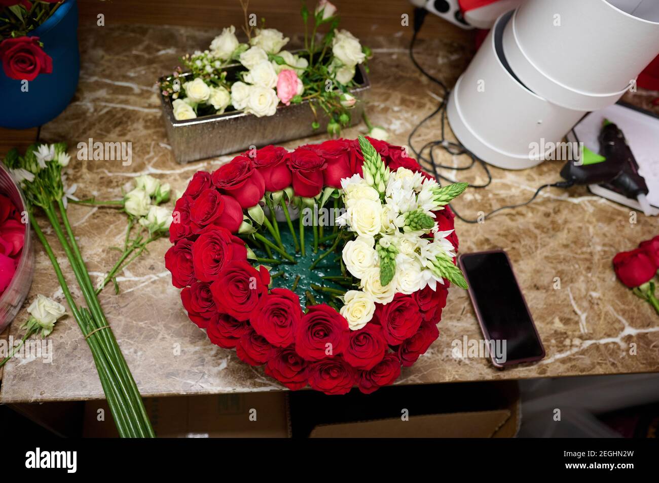 Flower box with red roses and white flowers on the table, flower box