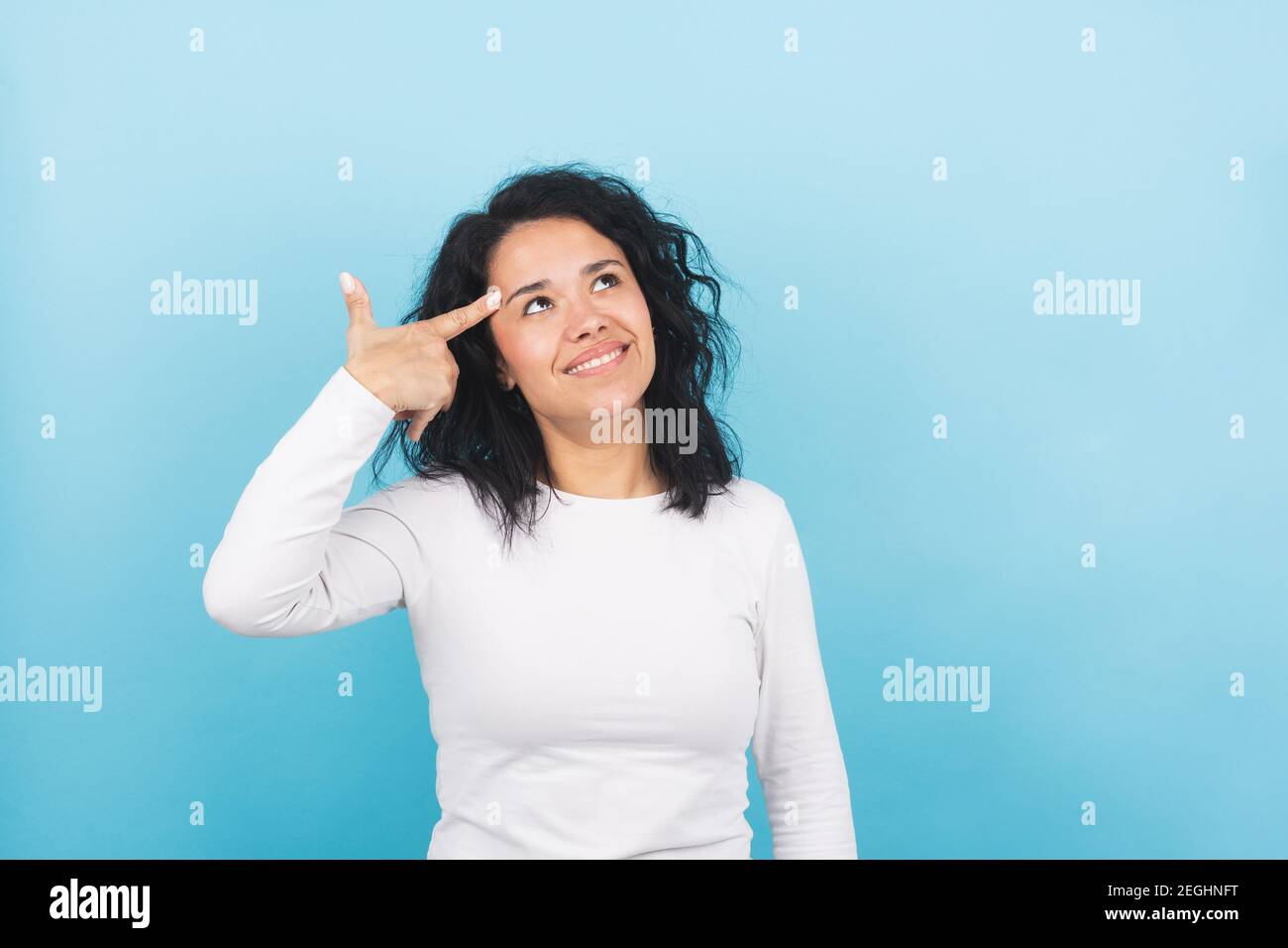 young brunette woman jokingly makes a gun gesture with her hand Stock Photo