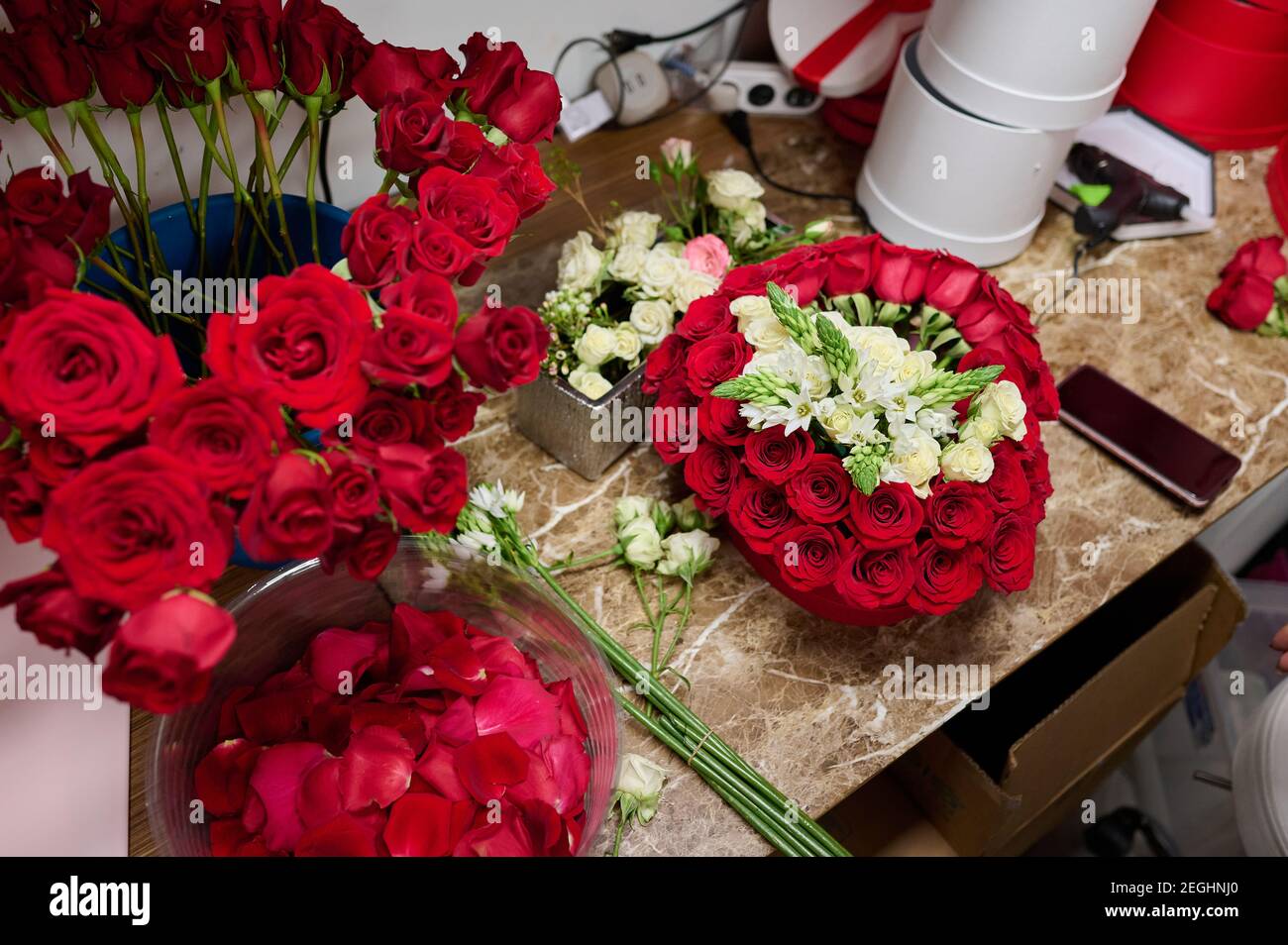 Flower box with red roses and white flowers on the table, flower box