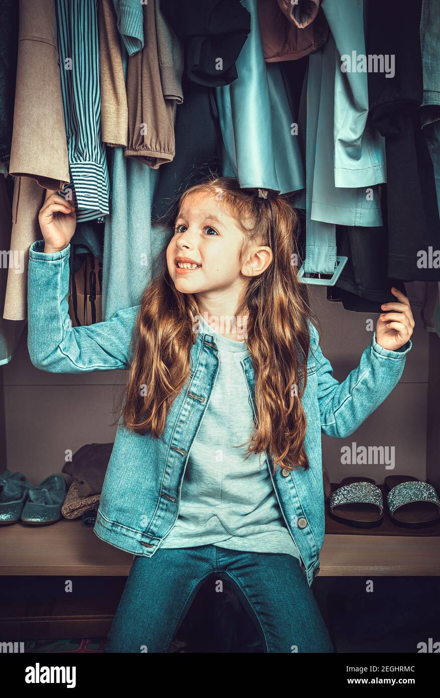 https://c8.alamy.com/comp/2EGHRMC/funny-little-girl-having-fun-in-the-wardrobe-with-clothes-2EGHRMC.jpg