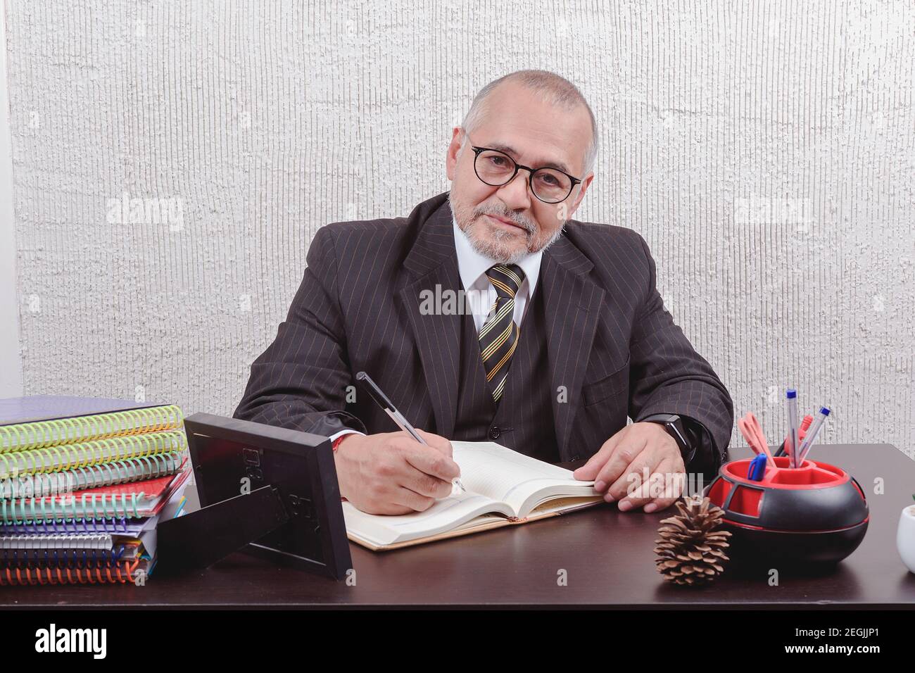 Closeup on a school teacher sitting at his desk taking notes Stock ...