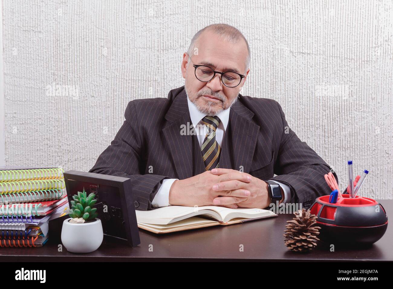 Closeup on a school teacher sitting at his desk taking notes Stock ...