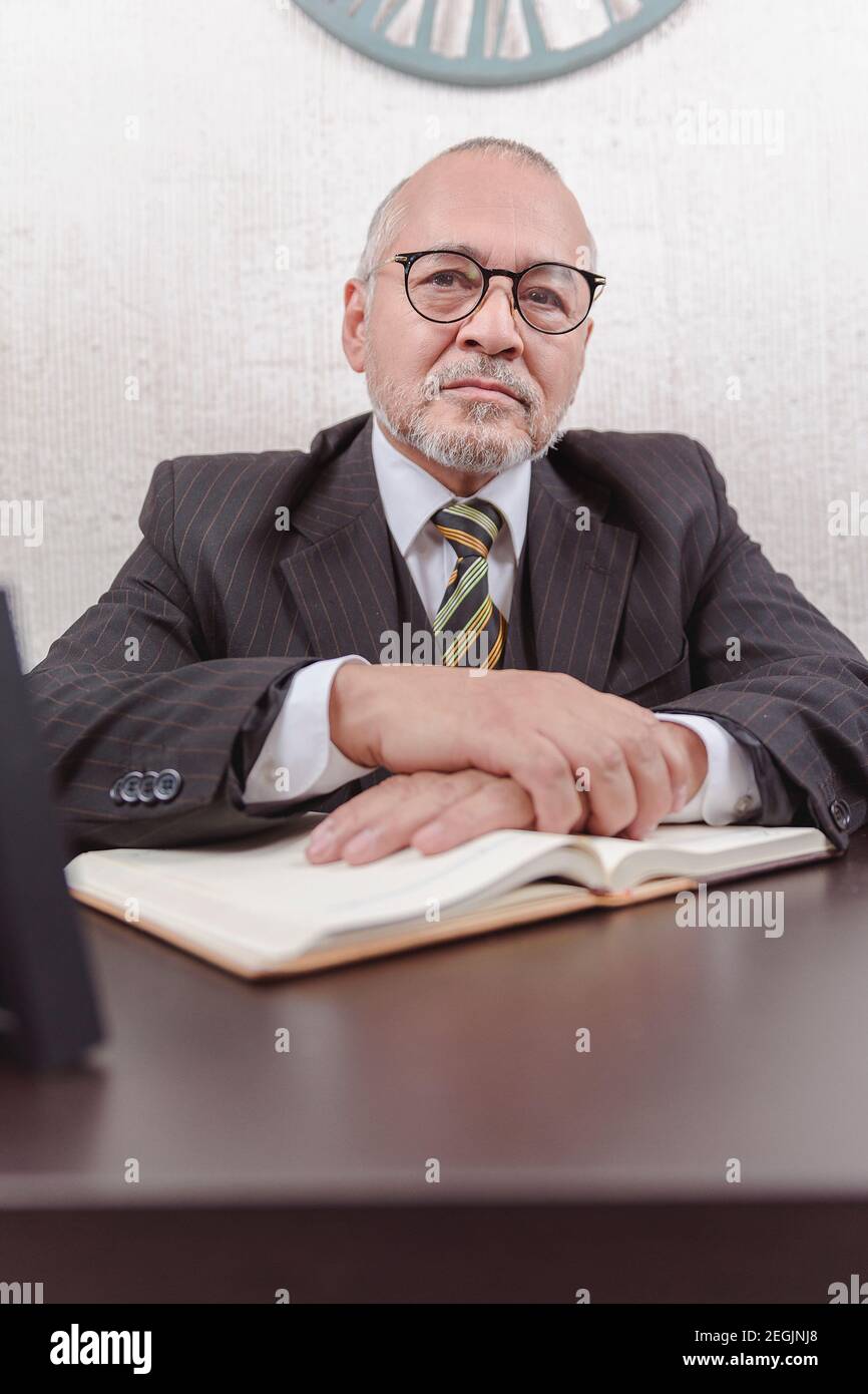 Closeup on a school teacher sitting at his desk taking notes Stock Photo