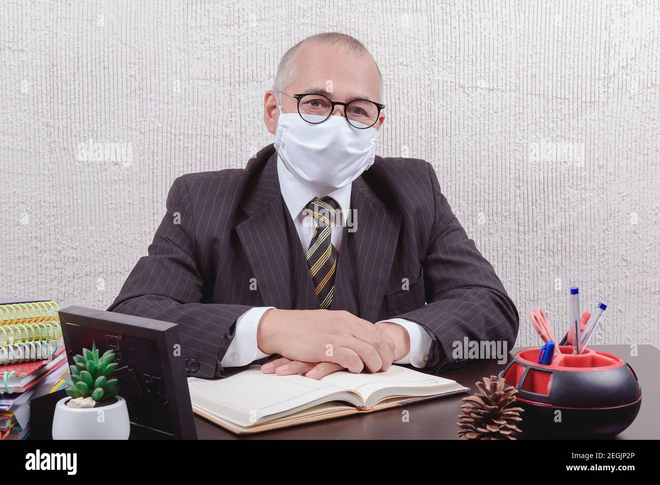 Closeup on a school teacher sitting at his desk taking notes Stock ...