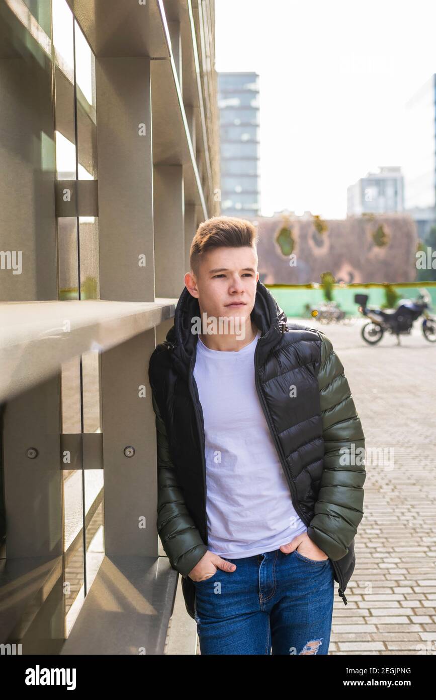 Stylish man standing with hands in pockets, while looking camera Stock Photo