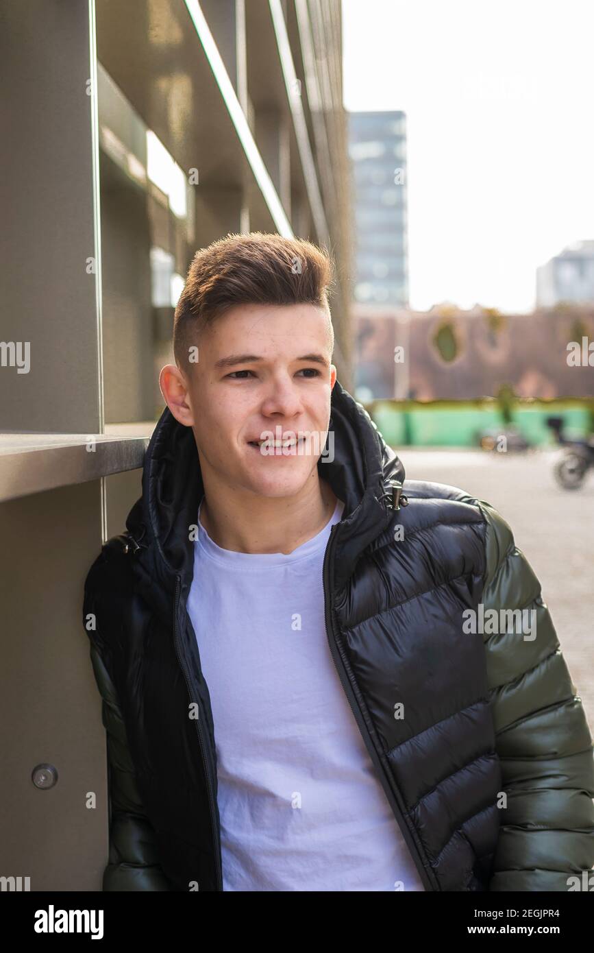 Smiling man standing with hands in pockets, while looking camera Stock Photo