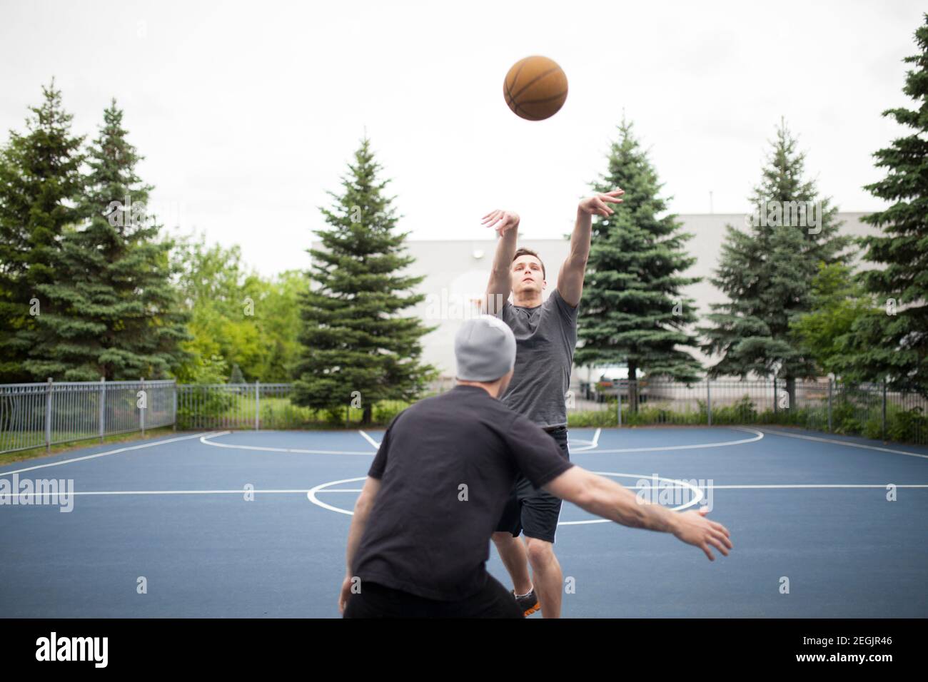 Two friends playing basketball together in outdoor setting Stock Photo Alamy