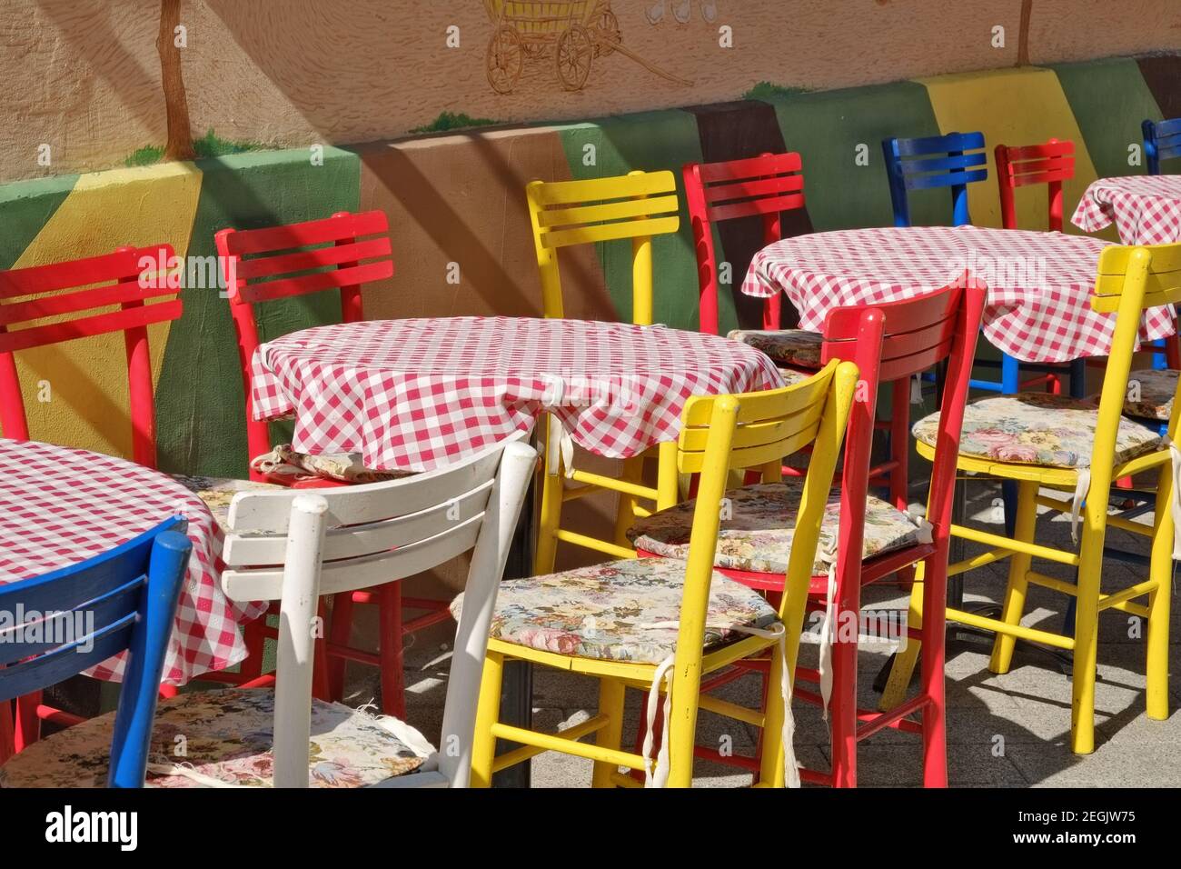 colorful chairs and tables with red checked tablecloth in a street of Novi Sad, Serbia Stock Photo