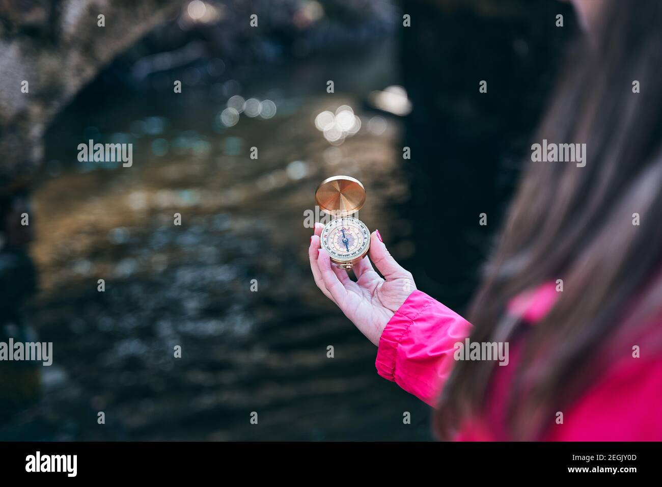 Girl Hand with compass at mountain road for better orientation in the river Stock Photo