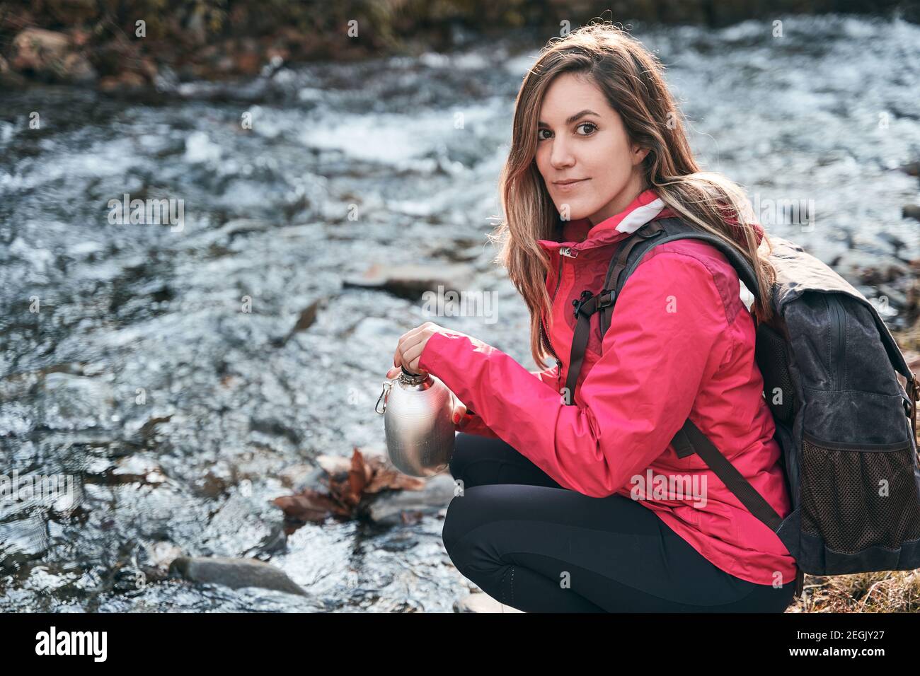 girl scout on the river bank with a canteen of water Stock Photo