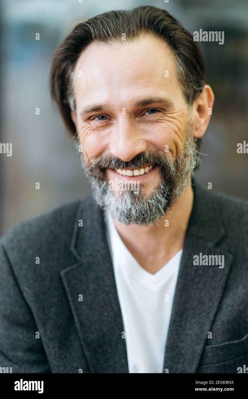 Portrait of joyful grey-haired mature businessman in formal stylish suit. Happy successful entrepreneur looking directly at the camera with friendly smile Stock Photo