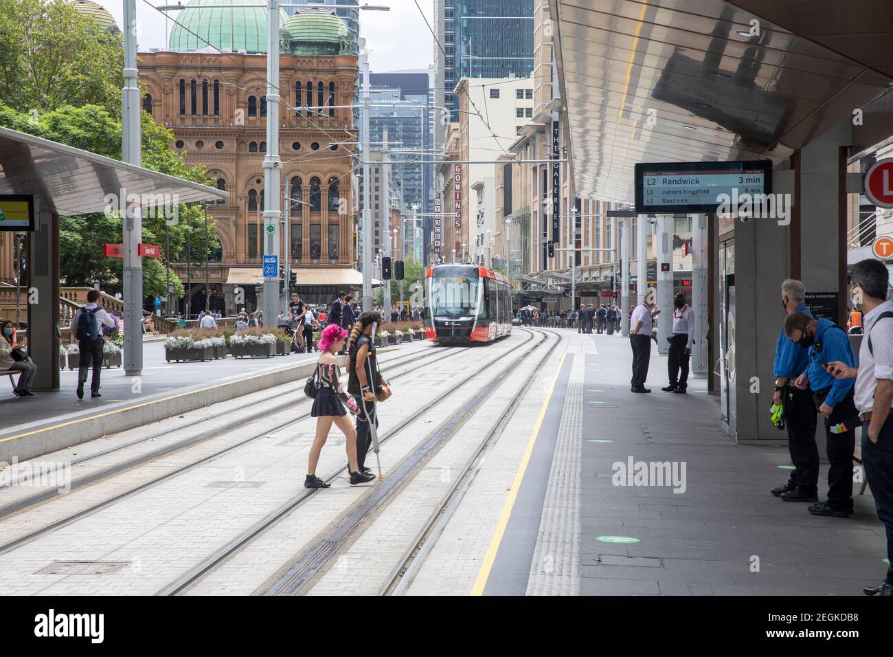 Sydney couple in punk clothing cross George Street as train approaches,Sydney Town Hall station,Australia Stock Photo